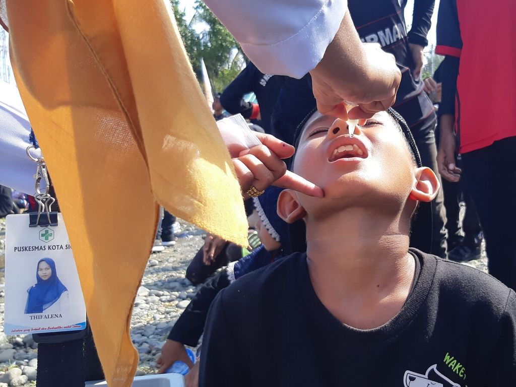 Para tenaga kesehatan meneteskan imunisasi polio kepada salah seorang anak sekolah dasar dalam subpekan imunisasi nasional di Kabupaten Pidie, Provinsi Aceh, Senin (28/11/2022). Imunisasi massal dilakukan pasca-penemuan empat kasus positif polio di kabupaten itu.