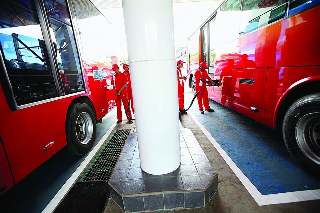 Petugas mengisikan bahan bakar gas jenis gas alam terkompresi (<i>compresed natural gas</i>/CNG) ke bus Transjakarta di stasiun pengisian bahan bakar gas Mampang, Jakarta Selatan, Kamis (16/5/2013). 