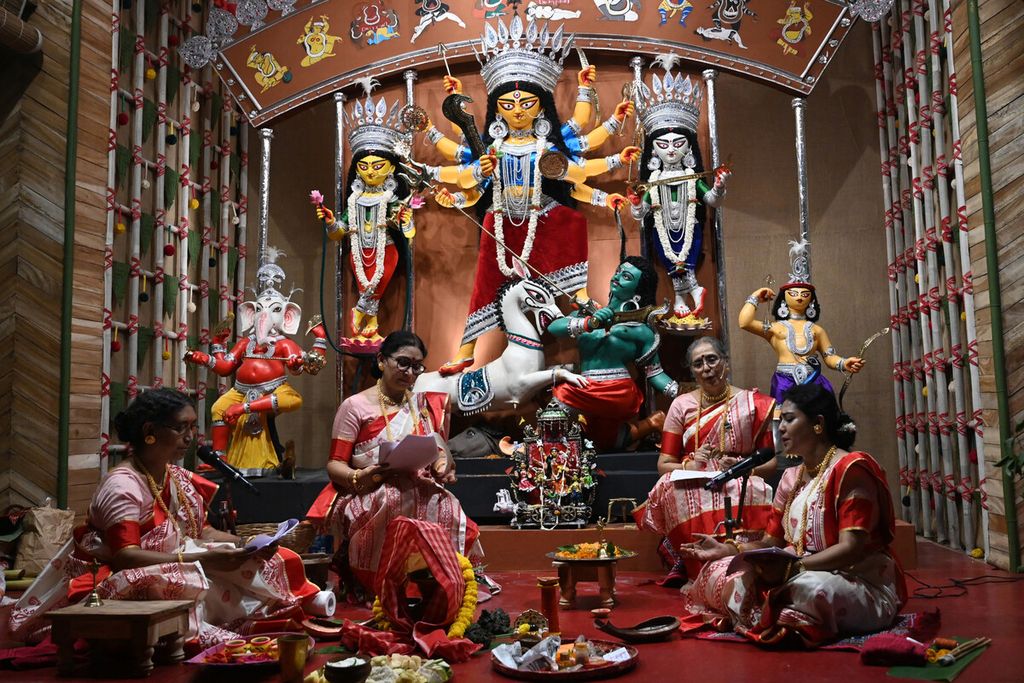 Pemuka agama Hindu melakukan ritual di depan berhala Dewi Durga pada rangkaian prosesi festival Durga Puja di Kolkata, India, Senin (11/10/2021).