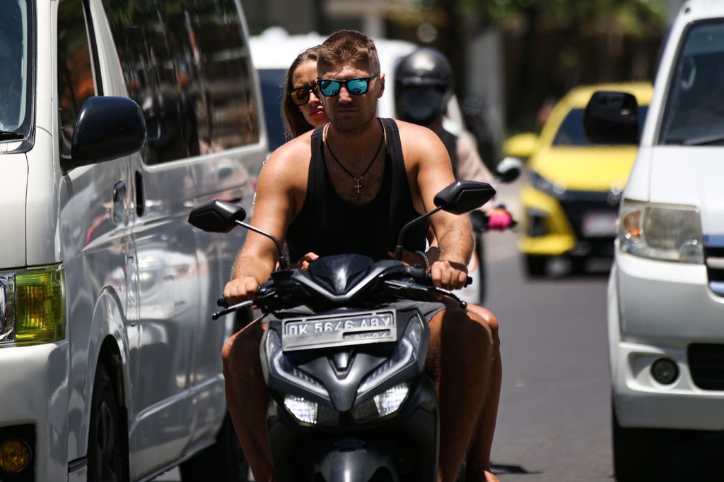 Turis asing berboncengan tanpa mengenakan helm saat mengendarai sepeda motor di kawasan Kuta, Bali, Sabtu (18/3/2023). Masih dijumpai turis asing yang tidak mentaati aturan lalu lintas saat mengendarai sepeda motor di Bali.