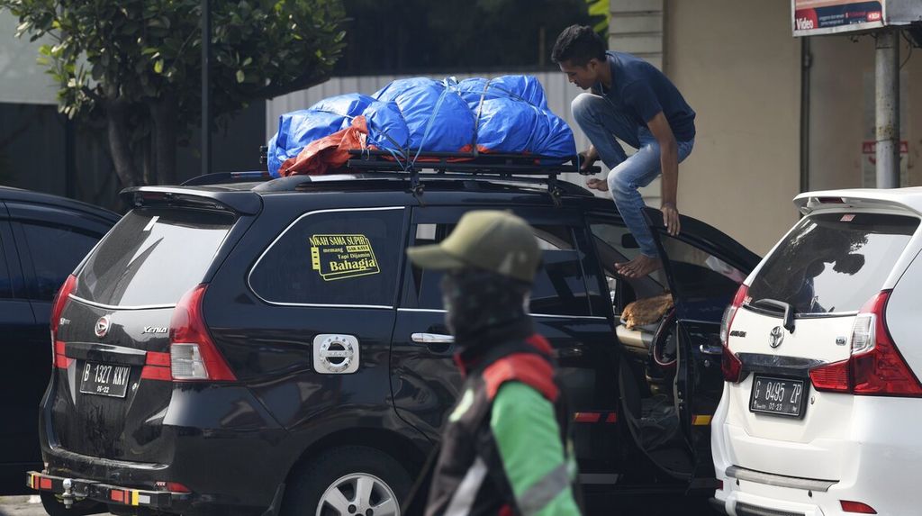Salah seorang pemudik memeriksa barang bawaan yang diletakan pada atap kendaraan saat beristirahat di Rest Area Kilometer 57 Jalan Tol Jakarta-Cikampek, Senin (25/4/2022). 
