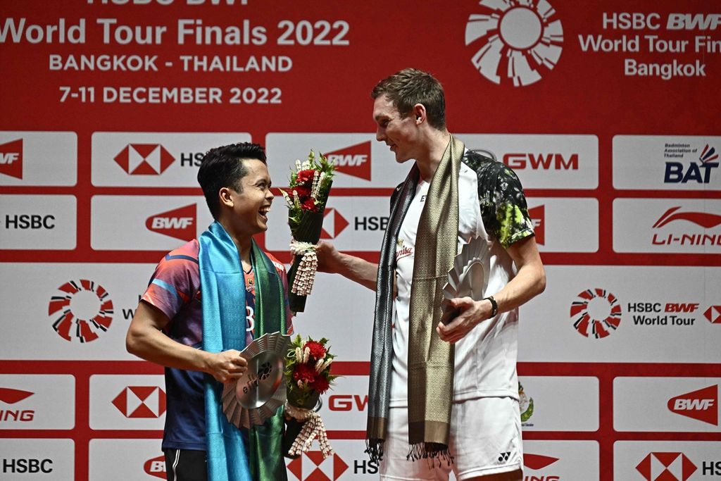 Viktor Axelsen (kanan) bergurau dengan Anthony Sinisuka Ginting di podium juara seusai laga final tunggal putra turnamen Final BWF World Tour di Bangkok, Thailand, Minggu (11/12/2022).
