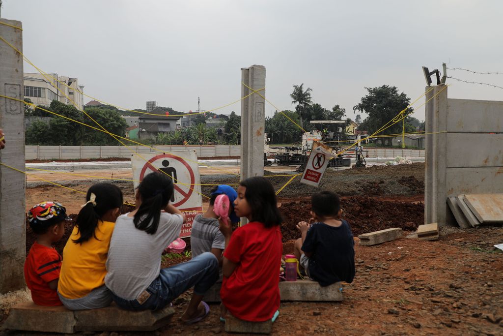 Anak-anak dan warga menonton pembangunan jalan tol Serpong-Balaraja di Cilenggang, Serpong, Tangerang Selatan, Minggu (13/2/2022). Pembangunan jalan tol yang ada di sekitar perkampungan mereka ini menjadi tontonan mereka setiap hari.