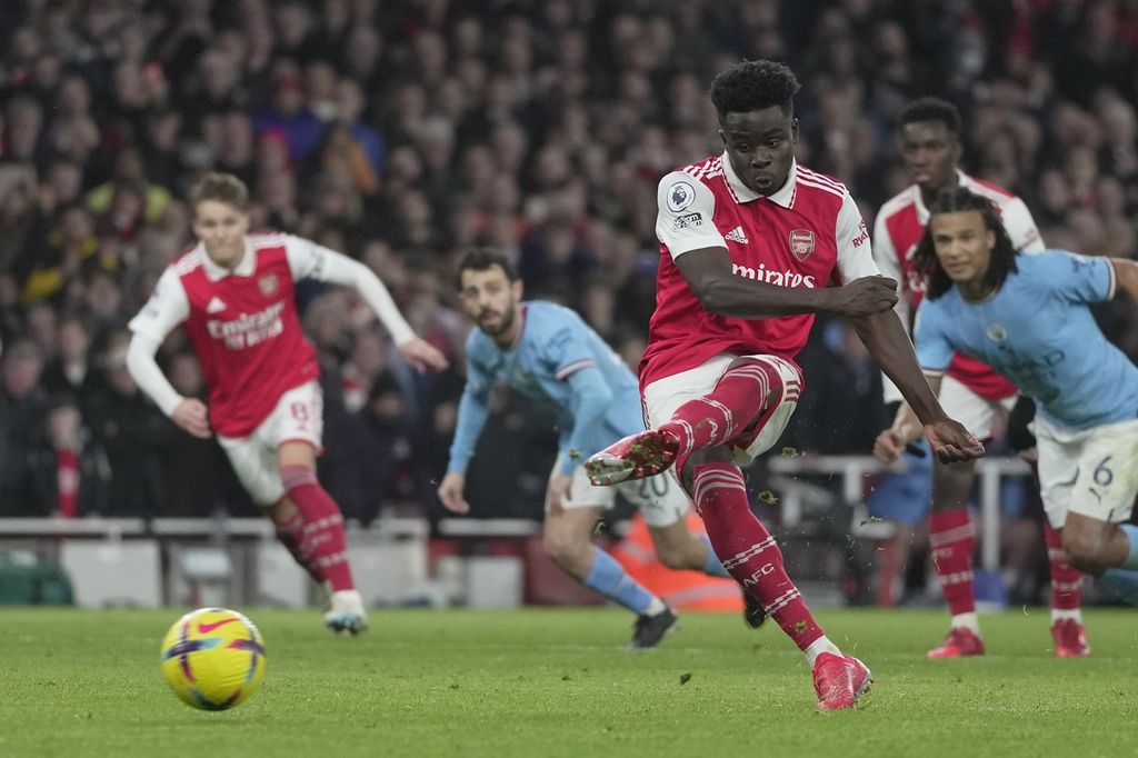 Pemain Arsenal, Bukayo Saka, menendang dari titik penalti untuk mencetak gol ke gawang Manchester City pada laga Liga Inggris di Stadion Emirates, London, Kamis (16/2/2023) dini hari WIB. City menang 3-1 pada laga itu.