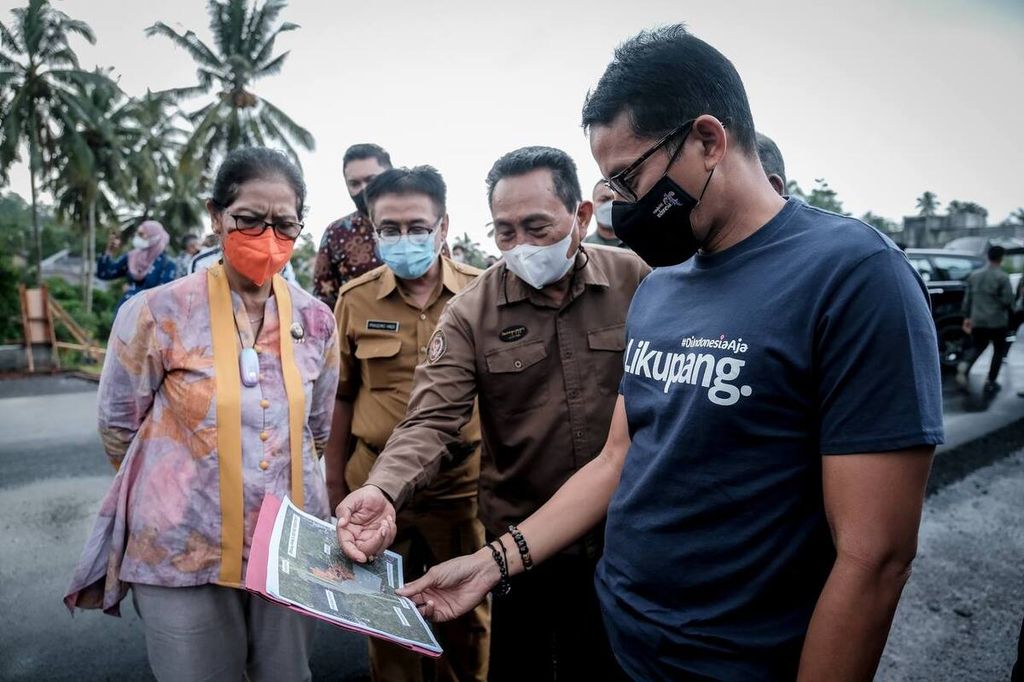 Menteri Pariwisata dan Ekonomi Kreatif Sandiaga Uno (kanan, berkaus biru) mengamati denah Politeknik Pariwisata Manado yang akan dibangun di Desa Kalasey Dua, Minahasa, Sulawesi Utara, dalam kunjungan pada Selasa (15/2/2022). Politeknik itu akan membuka pendaftaran bagi 2.500 siswa pada Juli 2022.