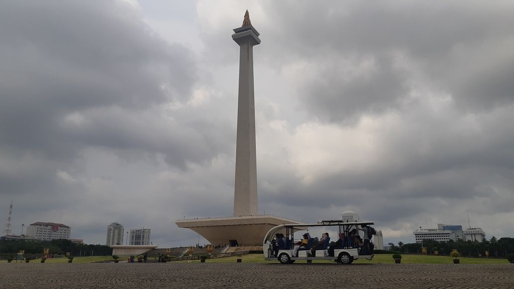 Warga berkeliling kawasan Monumen Nasional, Jakarta, Kamis (13/2/2020).