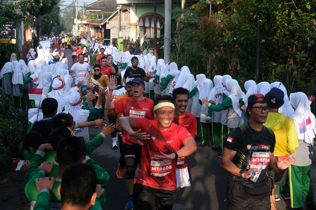 Siswa sekolah menampilkan atraksi untuk memberikan semangat kepada pelari Tilik Candi Borobudur Marathon 2022 Powered by Bank Jateng di Magelang, Jawa Tengah, Minggu (12/11/2022). Sebanyak 4.552 pelari mengikuti lomba lari dengan jarak 21,097 kilometer atau separuh maraton.
