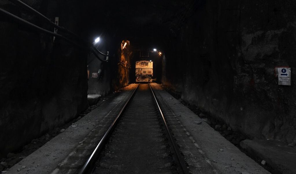 Kereta yang mengangkut material tambang berjalan menuju area stasiun bongkar muat tambang bawah tanah Grasberg Blok Cave (GBC) PT Freeport Indonesia di Tembagapura, Timika, Papua, Rabu (1/6/2022).  