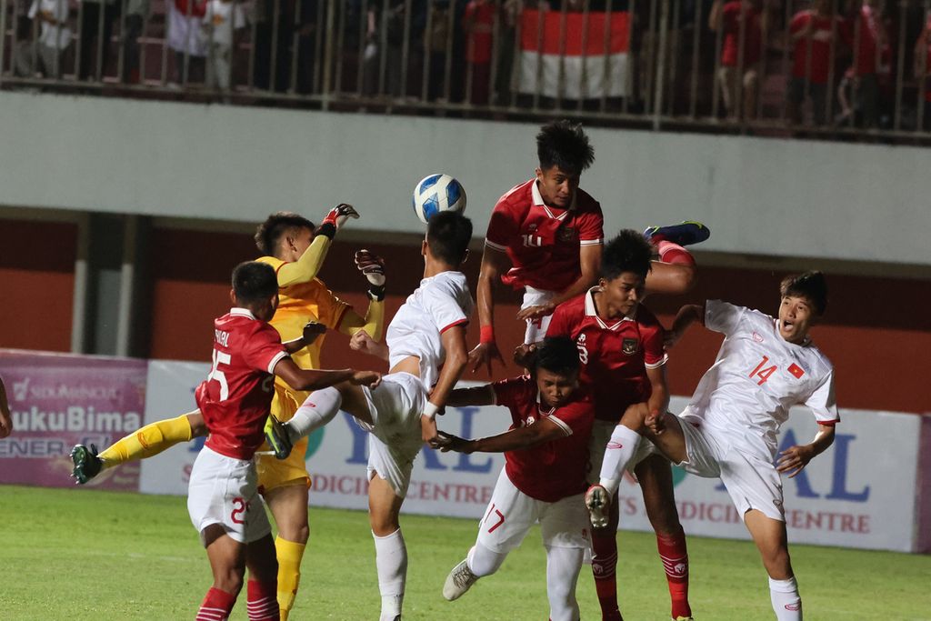Penjaga gawang Tim Vietnam U-16 Pham Dinh Hai (kostum kuning) berusaha membendung serangan tim Indonesia U-16 (kostum merah) dalam laga Piala AFF U-16 di Stadion Maguwoharjo, Sleman, DI Yogyakarta, Sabtu (6/8/2022). Indonesia menang 2-1 pada laga itu. 