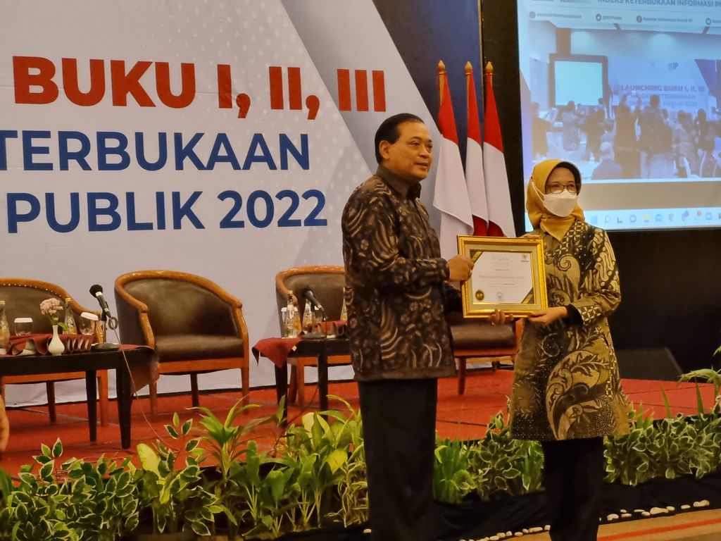 Ketua Komisi Informasi Pusat (KIP) Donny Yoesgiantoro menyerahkan penghargaan kepada Kepala Dinas Komunikasi dan Informatika Jawa Barat Ika Mardiah, Kamis (22/9/2022), di Bekasi, Jabar. 