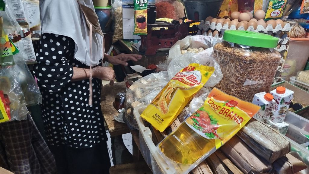 Pedagang di Pasar Cihapit, Kota Bandung, Jawa Barat, menunjukkan sejumlah minyak goreng kemasan, Kamis (20/1/2022). Di pasar ini, harga minyak goreng masih di kisaran Rp 20.000 per liter.