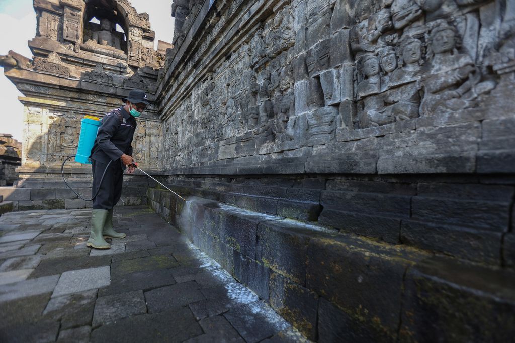 Petugas Balai Konservasi Borobudur menyemprotkan minyak atsiri di Candi Borobudur, Magelang, Jawa Tengah, Rabu (22/6/2022). Selama sepekan, minyak atsiri disemprotkan ke batuan di Candi Borobudur untuk menghilangkan lumut, kerak, dan jamur. 