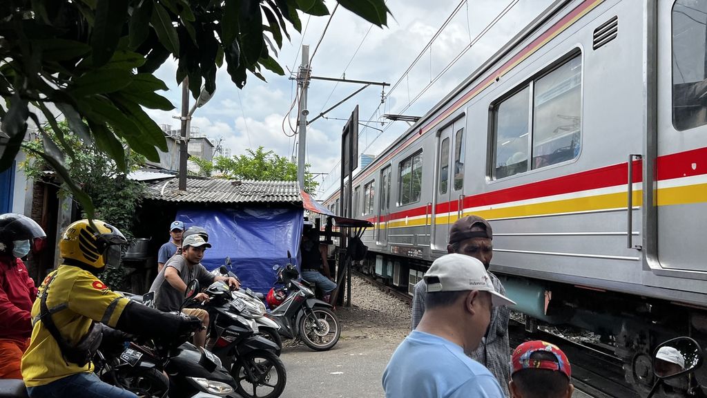 Kereta api saat melintas di pelintasan sebidang jalur kereta api Pintu Air Petamburan, Jakarta Pusat, Selasa (15/11/2022).