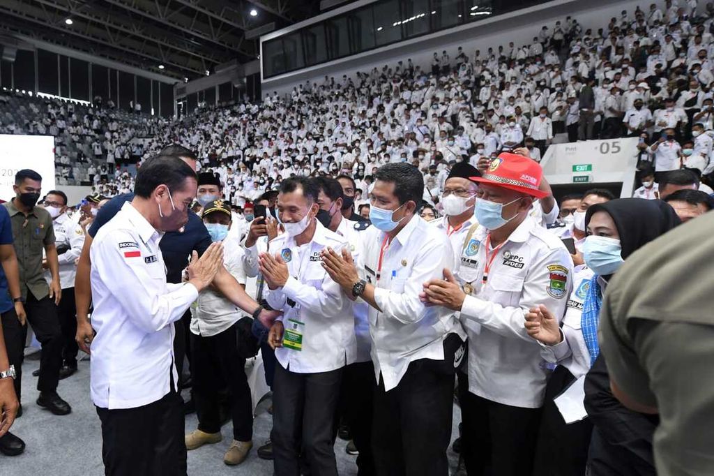 Presiden Joko Widodo menyapa para kepala desa yang hadir dalam Silaturahmi Nasional Asosiasi Pemerintah Desa Seluruh Indonesia (Apdesi) di Istora Senayan, Jakarta, Selasa (29/3/2022).
