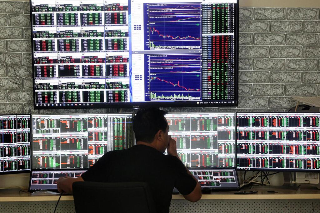 Pedagang saham, Himawan, sedang memantau pergerakan indeks harga saham di rumahnya di kawasan Pondok Aren, Tangerang Selatan, Banten, Senin (3/1/2022).