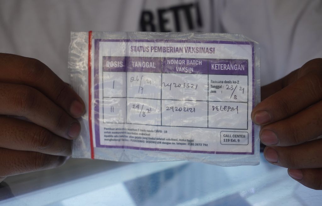 Pedagang ponsel menunjukkan kartu vaksinasinya kepada petugas gabungan yang sedang melakukan razia vaksinasi di Kelurahan Mangkukusuman, Kecamatan Tegal Timur, Kota Tegal, Jawa Tengah, Sabtu (6/11/2021). 