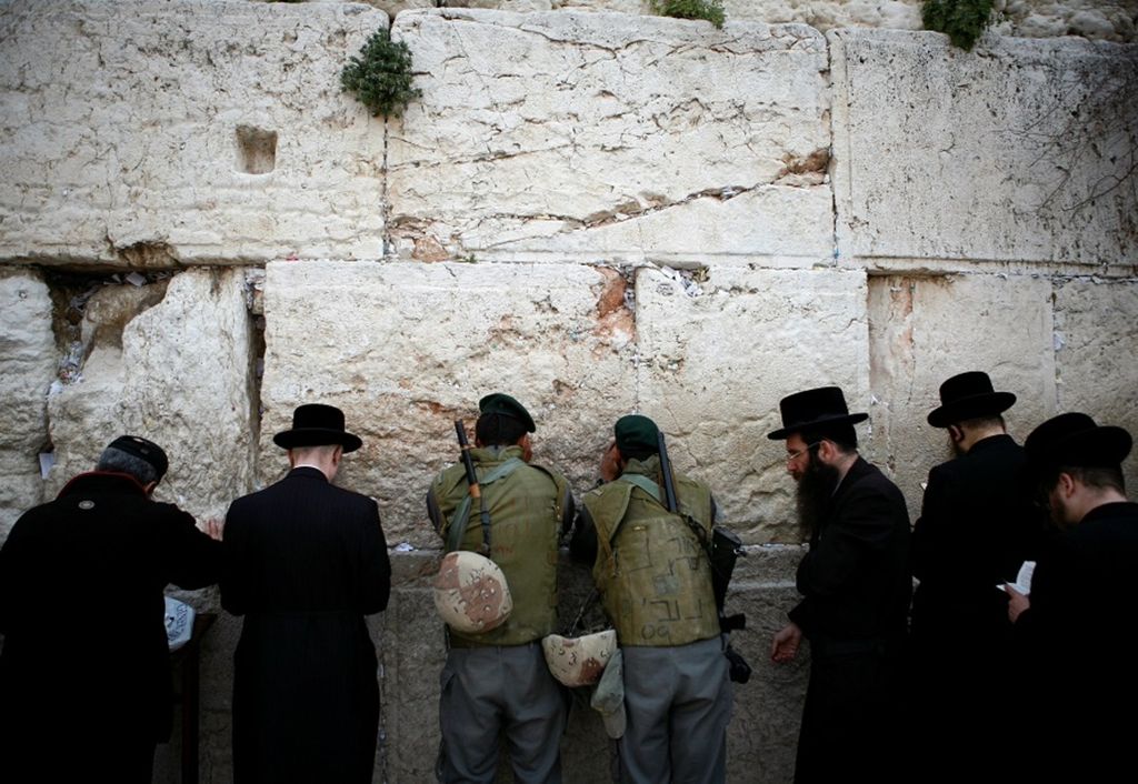 Warga penganut Yahudi, termasuk dua anggota polisi perbatasan Israel (tengah), berdoa di Tembok Ratapan, Kota Tua Jerusalem, 15 Maret 2010.