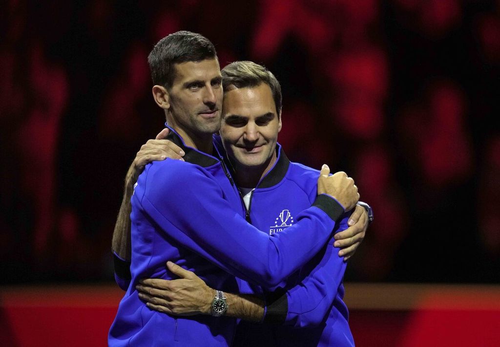 Petenis Tim Eropa Novak Djokovic dan Roger Federer (kanan) berpelukan pada akhir hari ketiga turnamen tenis Piala Laver di London, Minggu (25/9/2022).