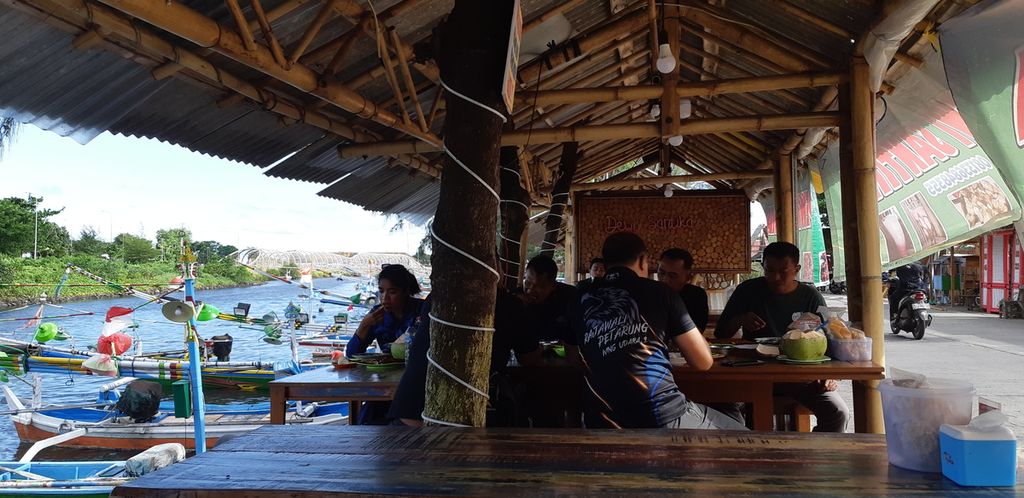 Wisatawan menikmati wisata kuliner ikan bakar di Fish Market, Kampung Mandar, Banyuwangi, Jatim, Selasa (10/1/2023). Kampung nelayan ini menjadi salah satu destinasi wisata menarik di ujung timur Pulau Jawa karena menawarkan aneka masakan ikan laut dengan bahan ikan segar. 