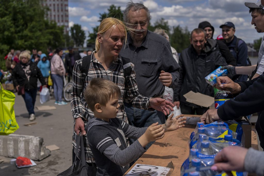 Sejumlah pengungsi, termasuk anak-anak, mengantre untuk mendapatkan jatah makanan di sebuah lokasi di Kharkiv, Ukraina, Kamis (19/5/2022). 