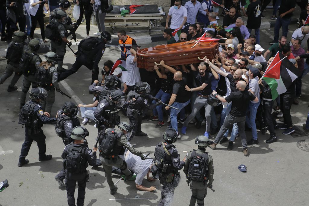 Polisi Israel menghadang rombongan warga yang mengusung peti jenazah jurnalis veteran Al Jazeera, Shireen Abu Akleh, dalam upacara pemakaman di Jerusalem timur, Jumat (13/5/2022). 