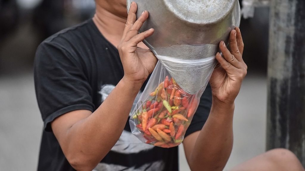 Pedagang sayur melayani pembeli cabai di Pasar Kebayoran Lama, Jakarta, Minggu (26/12/021). Lima hari menjelang pergantian tahun 2021 ke 2022, sejumlah harga sayur dan kebutuhan pokok lainya mengalami kenaikan. Harga cabai rawit merah di saat normal yang dihargai Rp 35.000 per kilogramnya saat ini telah mencapai Rp 120.000. Kenaikan harga sayuran dipicu oleh minimnya pasokan dari petani yang terdampak cuaca buruk.