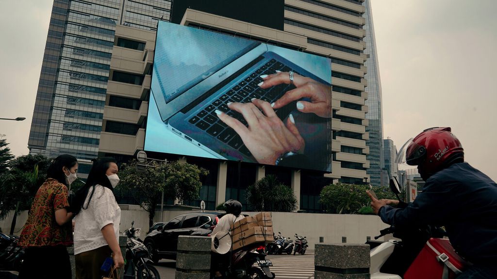 Pekerja kantoran melintasi jalur pedestrian di Jalan Sudirman, Jakarta Selatan, Rabu (28/4/2021). Saat ini, sebagian pekerja muda memilih bekerja secara <i>digital nomad,</i> tanpa ada kewajiban harus <i>ngantor</i>. 