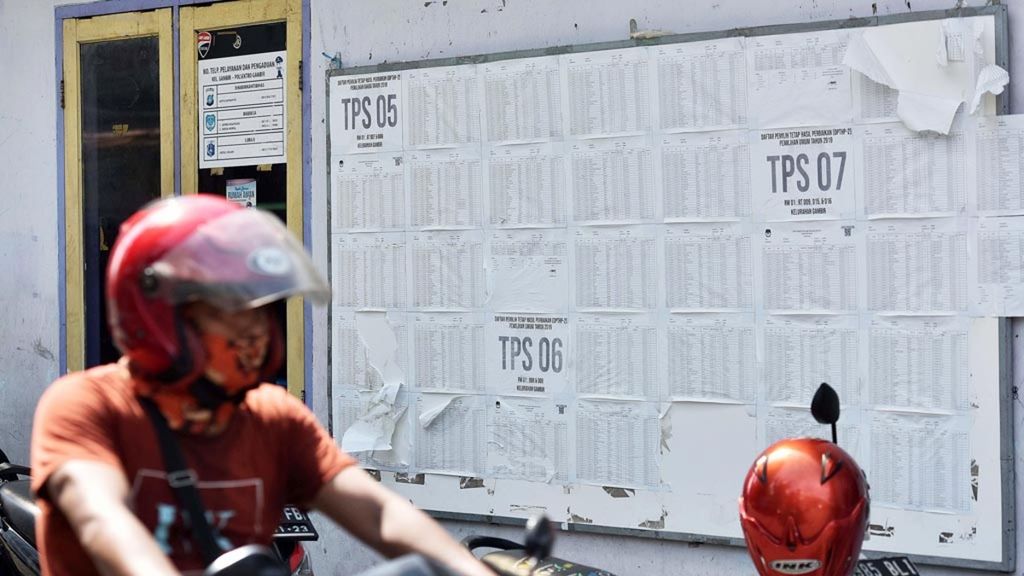 Warga melintasi Daftar Pemilih Tetap Hasil Perbaikan tahap II (DPTHP-II) yang ditempel di balai warga Kelurahan Gambir, Jakarta Pusat, Selasa (5/3/2019).