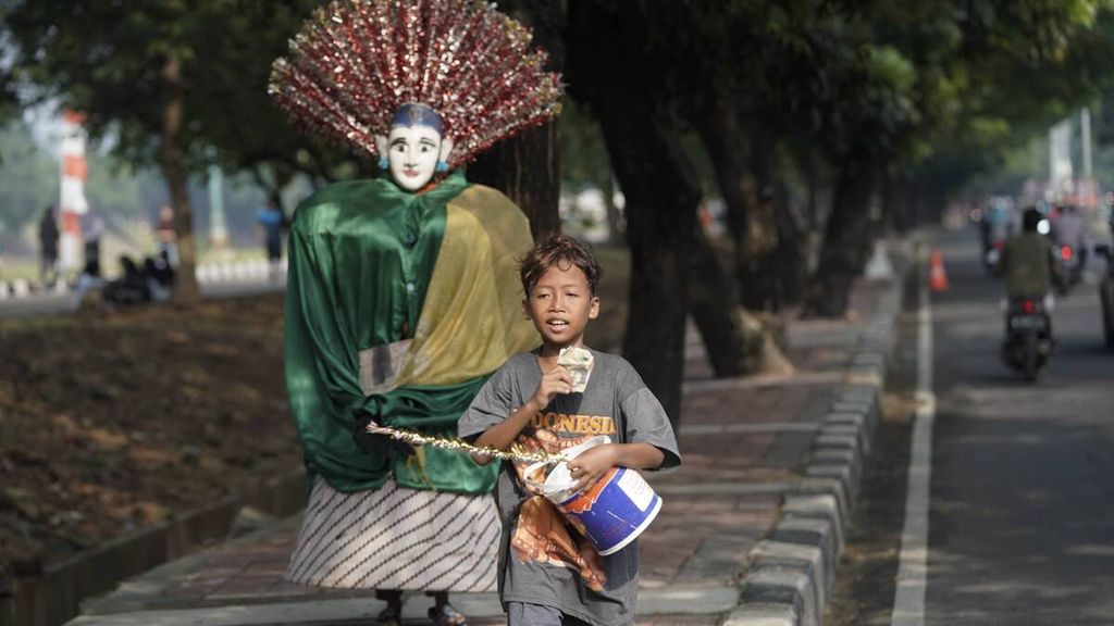 Anak-anak mengamen dengan membawa ondel-ondel di Jalan R.S. Soekanto, Jakarta Timur, Minggu (9/8/2020). Berdasarkan data Badan Pusat Statistik (BPS), terakhir kali ekonomi Indonesia tumbuh negatif pada triwulan I-1999, yakni minus 6,13 persen, sedangkan pada triwulan II-2020, perekonomian Indonesia tumbuh minus 5,32 persen secara tahunan. Pada Maret 2020, ada 26,42 juta orang miskin di Indonesia.
