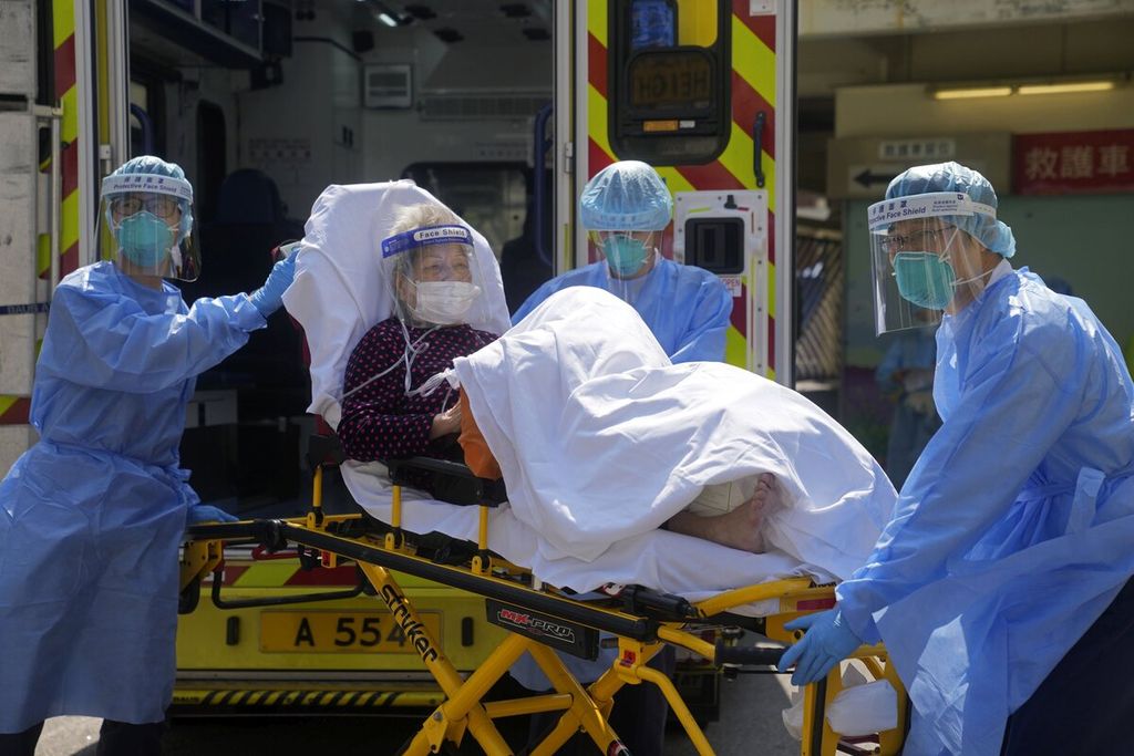 Petugas medis memindahkan seorang pasien lanjut usia dari ambulans ke rumah sakit di Hong Kong, Jumat (4/4/2022).