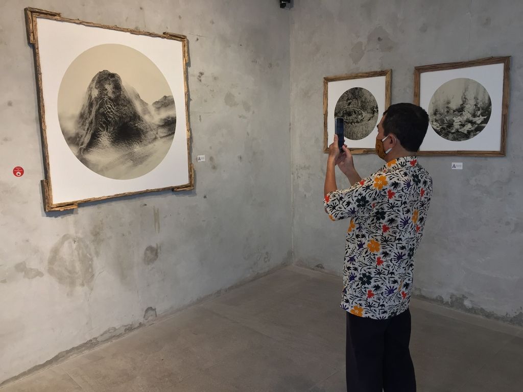 Pengunjung mengabadikan foto-foto karya artis visual Bernadette Godeliva Fabiola Natasha alias Kaze Kazumi yang sedang dipamerkan di Visma Art Gallery, Surabaya, Jawa Timur. Pameran fotografi bertema Puja berlangsung 11 Maret-11 April 2022. 
