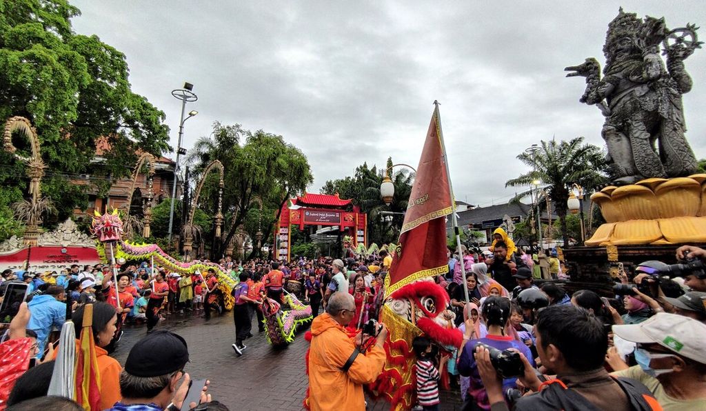 Warga di Kota Denpasar antusias menyaksikan pawai, yang memeriahkan pembukaan Festival Imlek Bersama 2023 di Kota Denpasar, Bali, Sabtu (28/1/2023). Pengunjung beramai-ramai menonton atraksi tari barongsai dan tari naga, yang ditampilkan secara massal di kawasan patung Catur Muka, Kota Denpasar, Sabtu (28/1/2023). 