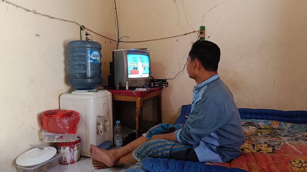 Irfan (40), Warga Kelurahan Depok, Kecamatan Pancoran Mas, Jawa Barat, menonton iklan masyarakat tentang migrasi dari siaran analog ke siaran digital, Kamis (6/10/2022).