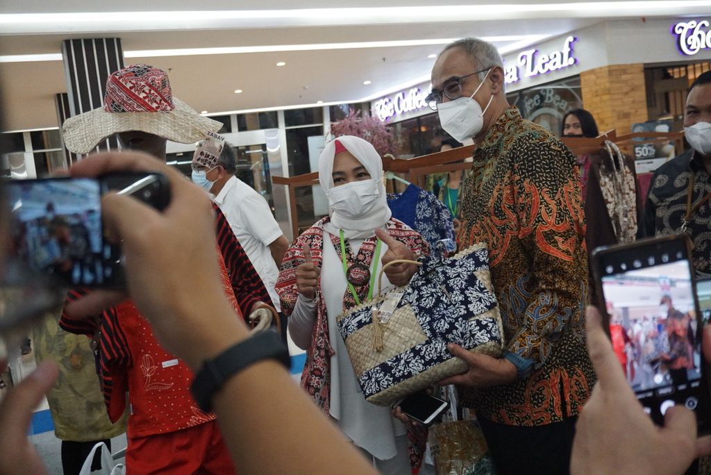 Direktur Jenderal Perdagangan Dalam Negeri Oke Nurwan berfoto bersama seorang perajin tas dalam pameran produk usaha mikro, kecil, dan menengah (UMKM) di Manado Town Square, Manado, Sulawesi Utara, Rabu (22/9/2021). Pameran yang diikuti 39 UMKM itu diharapkan dapat mendorong konsumsi produk-produk lokal.