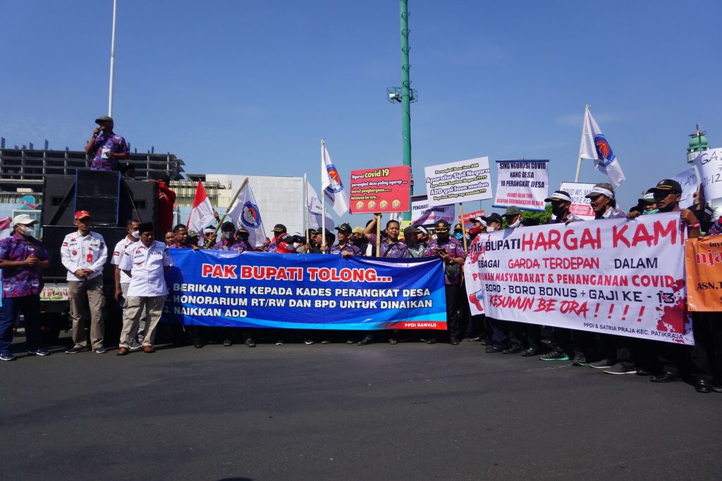 Para kepala desa dan perangkat desa se-Kabupaten Banyumas menggelar aksi damai menuntut tunjangan hari raya serta kesejahteraan di Alun-alun Purwokerto, Banyumas, Jawa Tengah, Senin (11/7/2022).