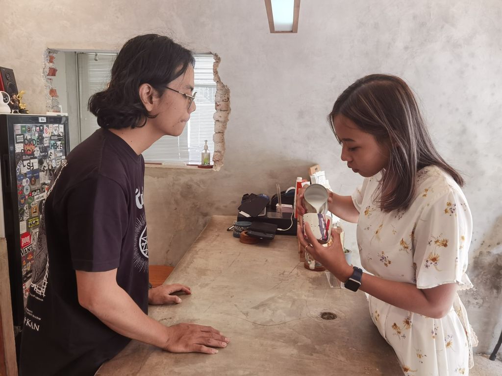 Lalu Wiliandi (31), barista sekaligus salah satu pemilik Harmos Brew di Jalan Pramuka, Karang Medain Barat, Kota Mataram, membantu seorang pengunjung yang belajar cara menyajikan kopi pada Kamis (27/10/2022).