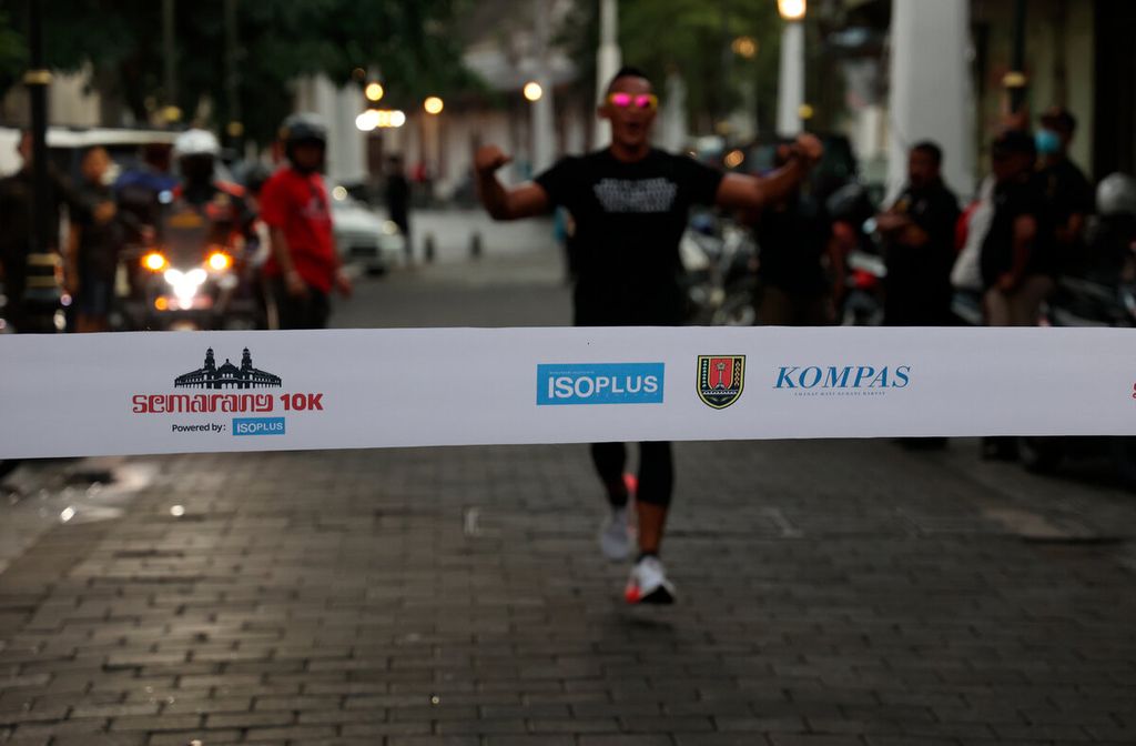 Salah satu pelari menuju garis finis saat mengikuti acara lari sore dalam rangka peluncuran kaus tim atau jersi dan medali Semarang 10K di Kota Lama, Kota Semarang, Jawa Tengah, Sabtu (3/12/2022).