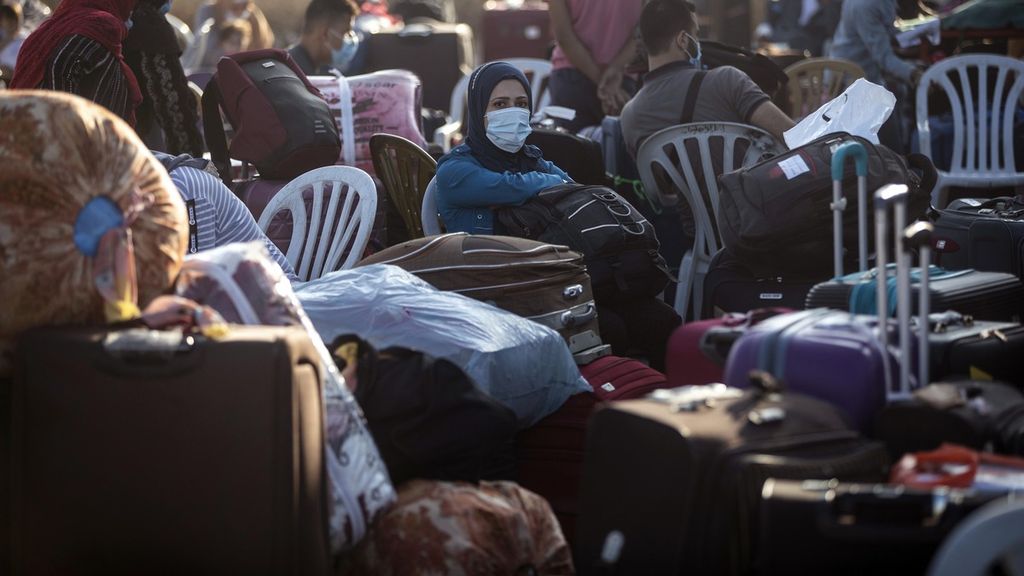 Pengungsi Palestina duduk diantara tumpukan koper saat menunggu dibukanya akses menuju Mesir dari perbatasan Rafah di Jalur Gaza, Minggu (27/9/2020).