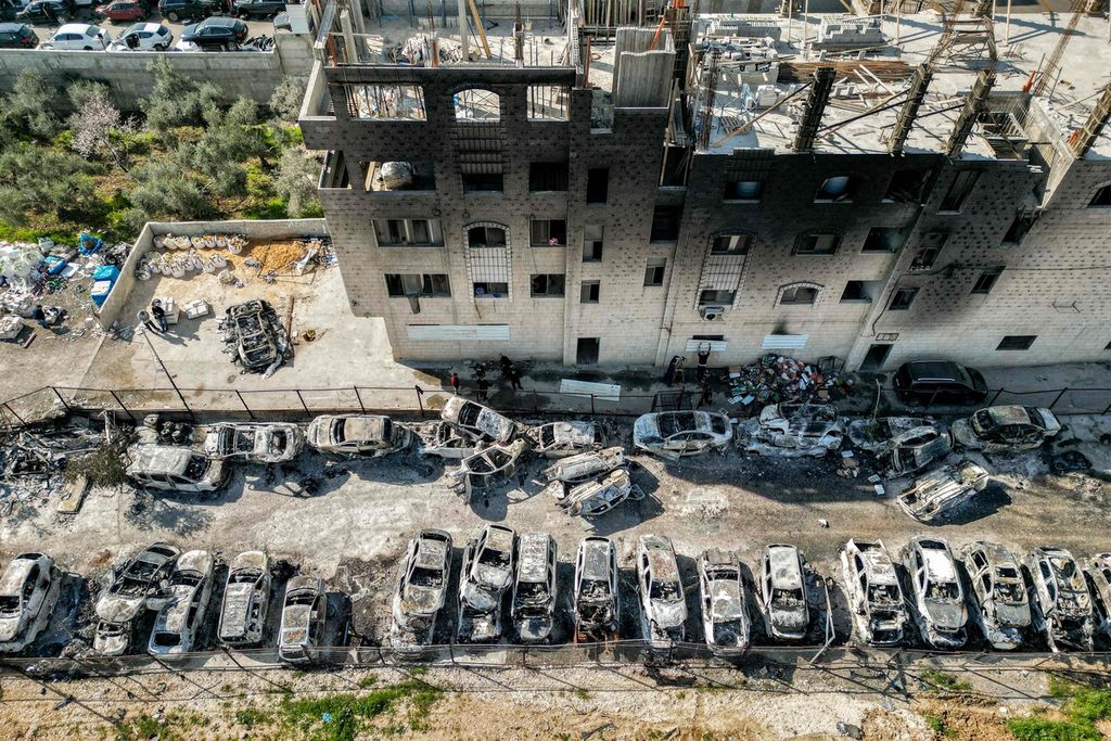 Dalam foto yang diambil pada 27 Februari 2023 ini terlihat pemandangan tempat pembuangan mobil-mobil yang dibakar pada malam sebelumnya di kota Huwara, dekat Nablus, wilayah pendudukan Tepi Barat. 