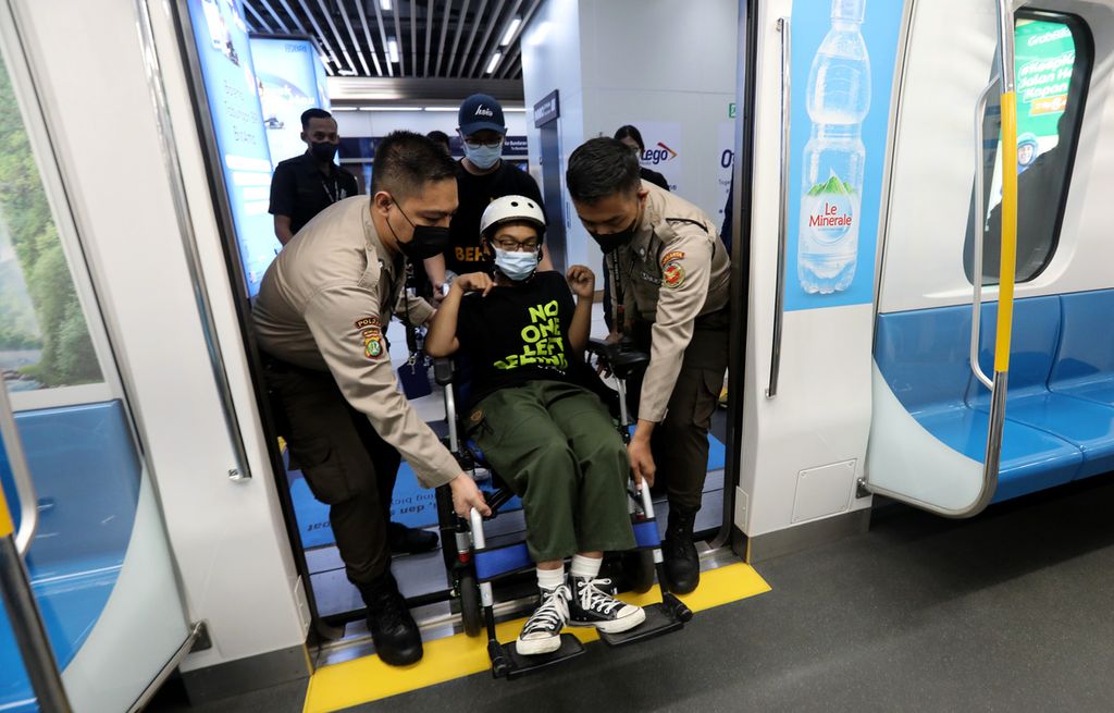 Sejumlah anggota gerakan penyandang Disabilitas dan Lanjut Usia (Dilans) Indonesia dibantu petugas saat memasuki kabin kereta Moda Raya Terpadu (MRT) di Stasiun MRT Dukuh Atas, Jakarta saat memperingati Hari Kursi Roda Internasional 2023, Rabu (1/3/2023). 