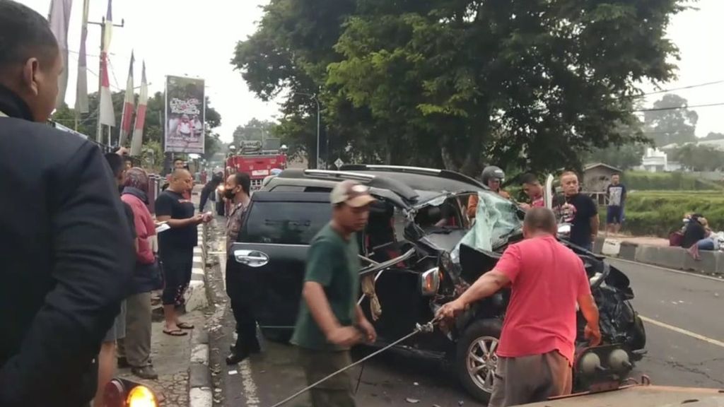 Warga mengevakuasi korban kecelakaan di Jalan Raya Cilowa, Kecamatan Kramatmulya, Kuningan, Senin (26/12/2022). Kecelakaan yang melibatkan bus dan mobil itu mengakibatkan dua warga meninggal.