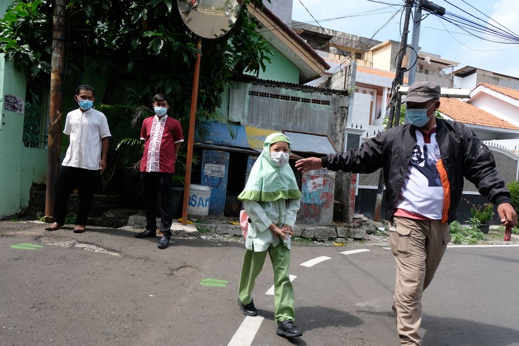Seorang bapak (kanan) menjemput anaknya pada jam pulang sekolah di SDN 07 Cideng, Jakarta, Jumat (24/9/2021). SDN 07 Cideng merupakan salah satu sekolah yang menggelar pembelajaran tatap muka (PTM) terbatas di Jakarta. Para siswa wajib diantar-jemput untuk meminimalkan risiko paparan virus Covid-19.