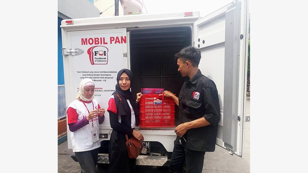Karyawan Foodbank of Indonesia memasukkan boks makanan usai menyalurkan makanan di Jakarta Utara.