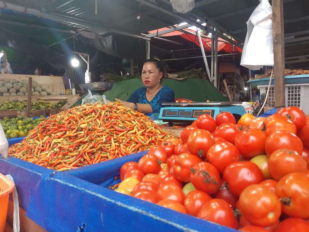  A trader sells cayenne pepper and tomatoes, Sunday (10/7/2022), at Bersehati Market, Manado, North Sulawesi. The price of shallots and cayenne pepper soared to Rp. 100,000 per kg.