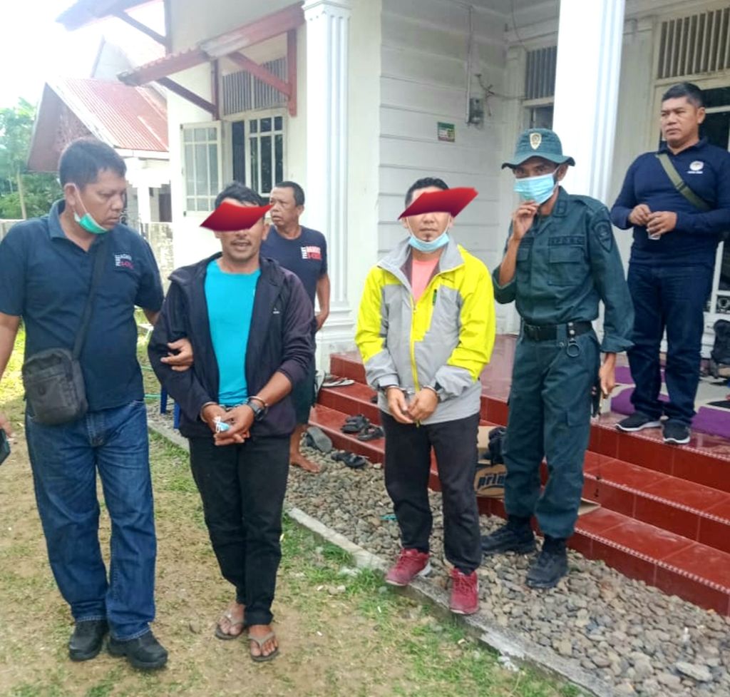 Dua terduga pelaku perdagangan kulit dan tulang harimau sumatera saat ditahan petugas Balai Pengamanan dan Penegakan Hukum Lingkungan Hidup dan Kehutanan Wilayah Sumatera, Rabu (25/5/2022). Satu di antaranya adalah mantan Bupati Bener Meriah, Provinsi Aceh, Ahmadmi (jaket kuning).