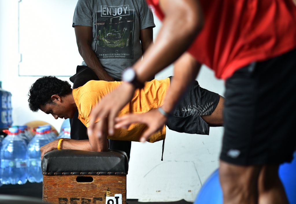 Sprinter nasional Lalu Muhammad Zohri berlatih fisik diawasi asisten pelatih sprinter pelatnas Erwin Maspaitella di ruang kebugaran Stadion Madya Gelora Bung Karno, Senayan, Jakarta, Selasa (5/7/2022). 