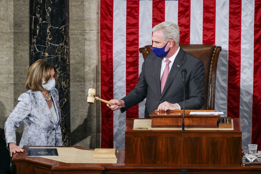 Pemimpin Minoritas Kongres Kevin McCarthy dari Partai Republik menyerahkan palu kepada Ketua Kongres AS Nancy Pelosi dari Partai Demokrat pada hari pembukaan Kongres ke-117 di Gedung Capitol, Washington, AS, Minggu (3/1/2021).