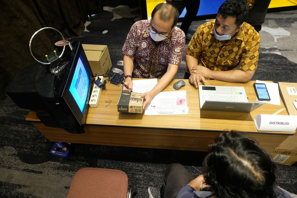 Petugas posko pengaduan mengecek <i>set top box</i> televisi digital yang akan diberikan kepada warga di The Akmani Hotel, Jakarta Pusat, Jumat (4/11/2022). 