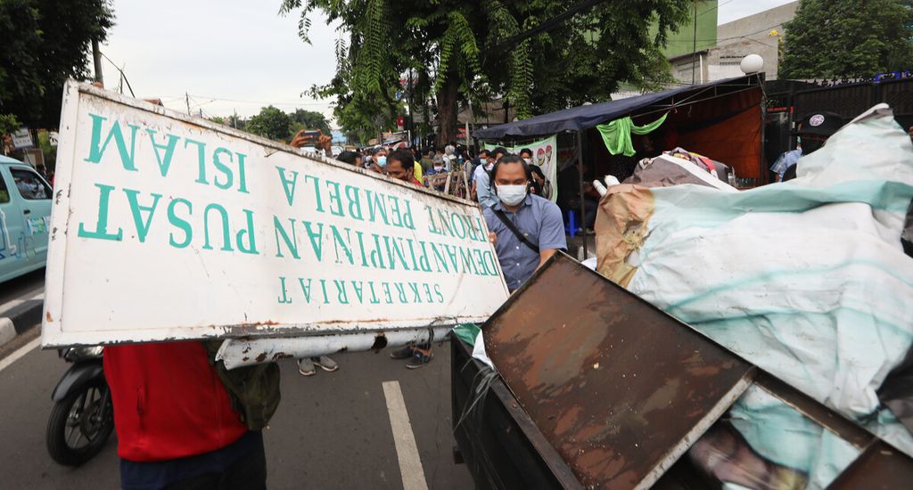 Petugas mengumpulkan atribut-atribut yang dibongkar saat menutup markas DPP Front Pembela Islam (FPI) di Petamburan, Jakarta Pusat, Rabu (30/12/2020). Polri dan TNI menutup markas FPI setelah pemerintah memutuskan untuk membubarkan organisasi tersebut.