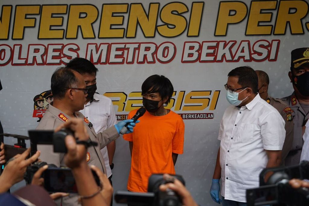 Rezy Saputra alias Kenji (26) saat dihadirkan di Polres Metro Bekasi, Senin (11/7/2022) siang. Dia ditangkap polisi karena menyiram air keras ke istri, anak, dan mertuanya.